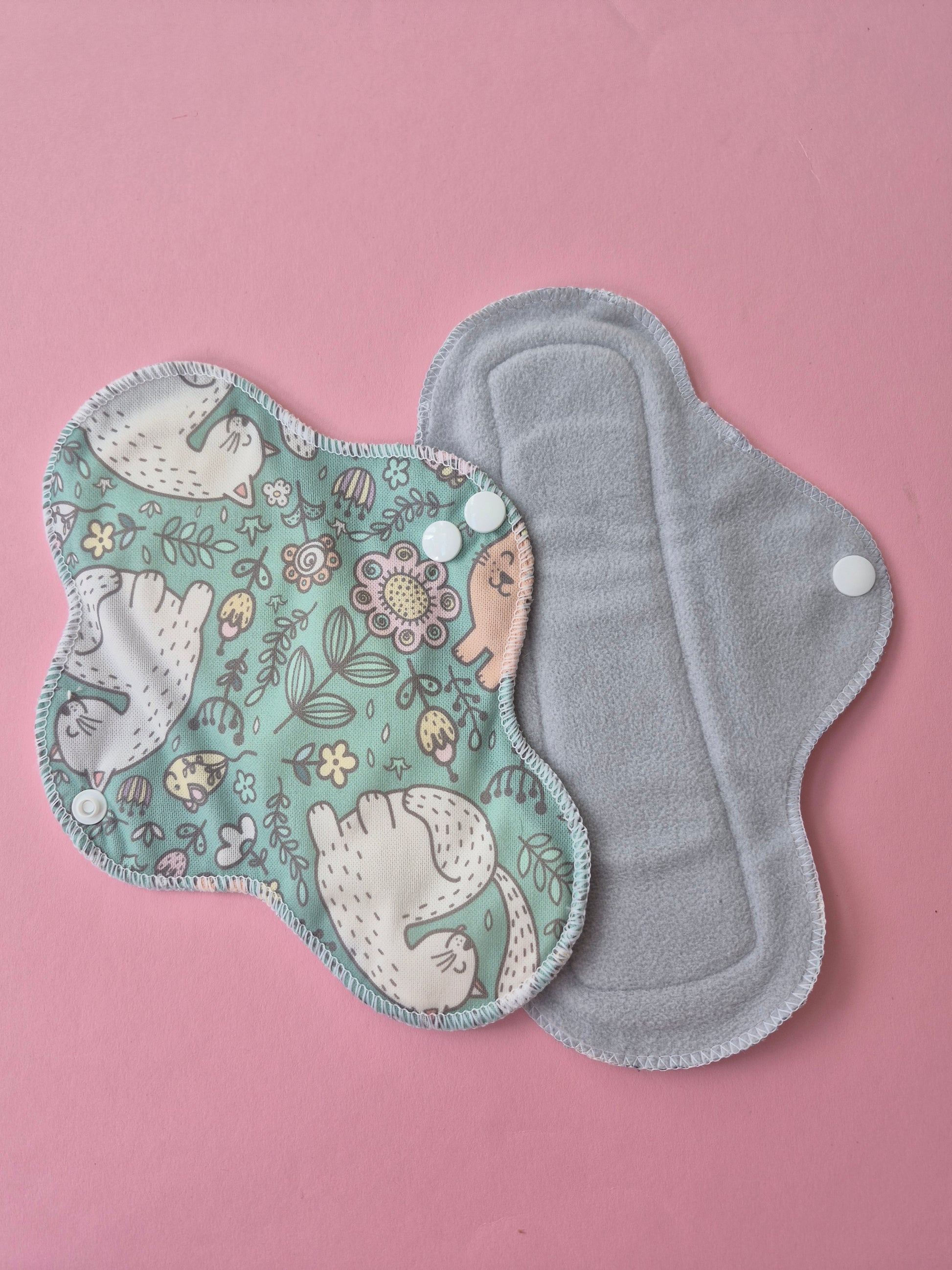 Reusable menstrual pad with floral pattern on a pink background
