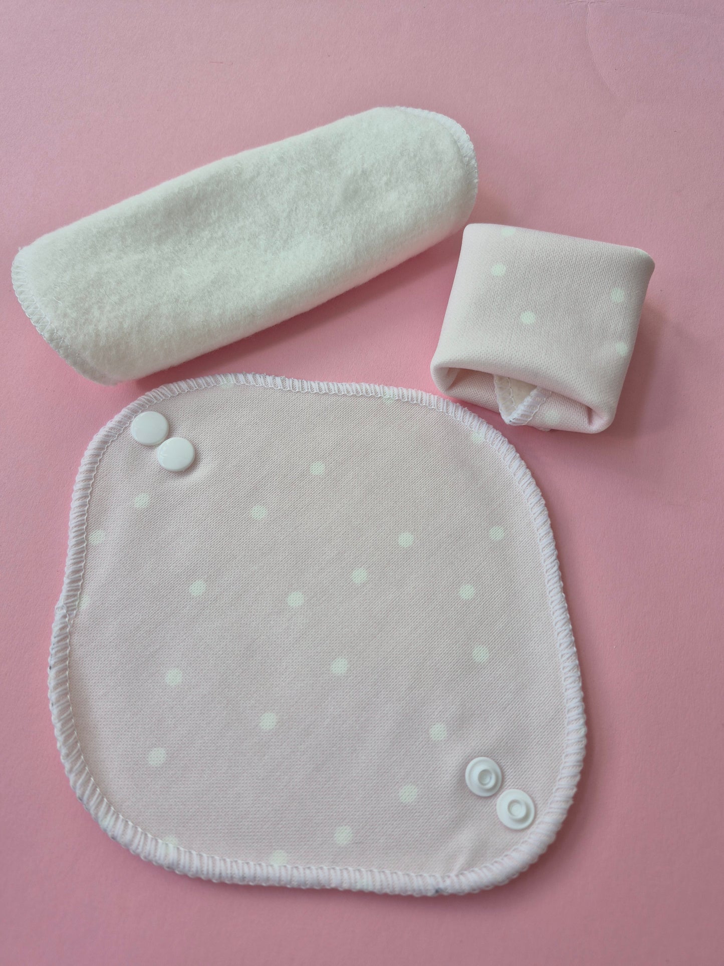 Set of light  pink polka dot panty liners on a pink background